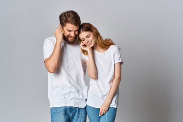 young couple in white t-shirts listening to music