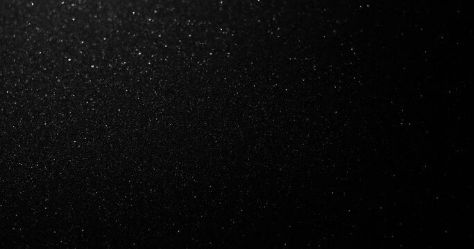 Silver glitter black sand or diamond dust creating abstract shimmering glow formations blinking  metamorphosis. Art background texture glamour