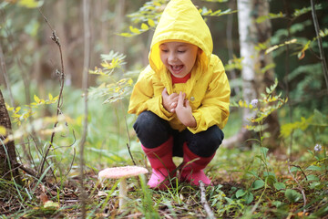 Children in the village walk through the autumn forest and gather mushrooms. Children in nature are...