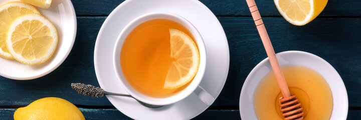 Lemon tea with honey panorama. The natural remedy of sweet raw honey and organic lemons, overhead...