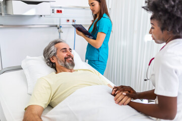Healthcare concept of professional doctor consulting and comforting elderly patient in hospital bed or counsel diagnosis health. Medical doctor or nurse holding senior patient's hands