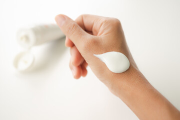 Woman applying lotion on hand with white background to test for allergy. thailand skin tan...