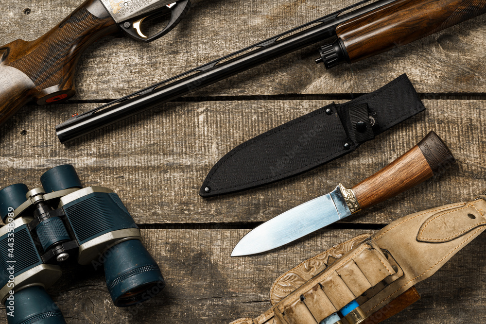 Wall mural hunting equipment on old wooden background including rifle, knife, binoculars and cartridges