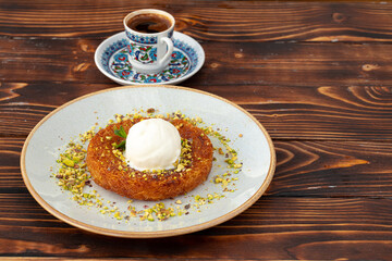 Turkish dessert kunefe with ice cream ball on wooden background