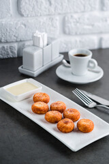 Homemade cottage cheese pancakes with condensed milk on gray background, breakfast