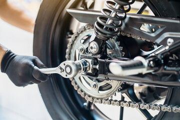 Mechanic using a wrench and socket to Remove and Replace Rear Motorcycle Wheel  , maintenance,...