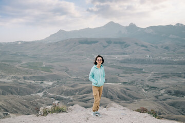 Woman hiker standing on a background of a mountain landscape.