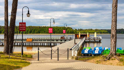 Jetty pier and public beach at Necko lake shore in Masuria lake district resort town of Augustow in Podlaskie voivodship of Poland - obrazy, fototapety, plakaty