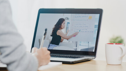 Young Asia teen girl university student using laptop computer distance learn lesson with female teacher remote teaching on internet at home. Social distancing, quarantine for corona virus prevention.