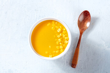 Corn soup, shot from the top with a wooden spoon. Simple vegan broth recipe