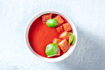 Tomato soup with basil, healthy vegan detox dish, top shot. Spring lunch
