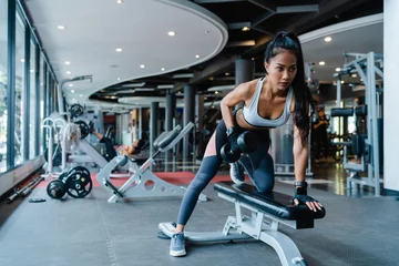 Foto auf Acrylglas Schöne junge asiatische Dame, die in der Fitnessklasse das Fettverbrennungstraining mit Langhanteln durchführt. Athlet mit Sixpack, Sportlerin Freizeitaktivität, funktionelles Training, gesundes Lifestyle-Konzept. © tirachard