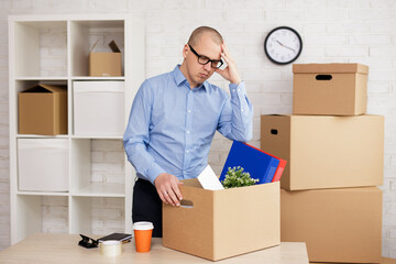 sad businessman packing things in boxes for moving