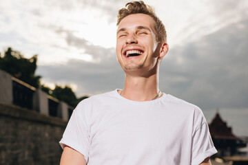 Smiling young man at the sky background