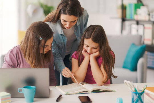 Young Mother Helping Kids With Their Homework