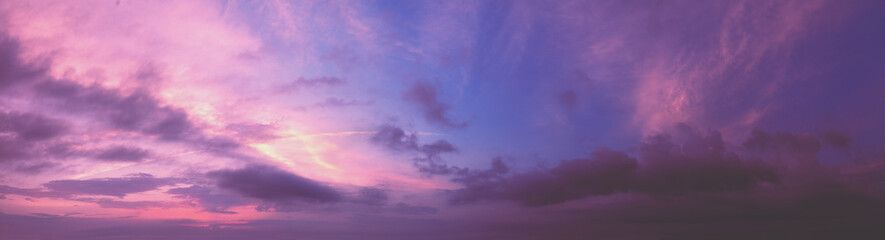 Naklejka na ściany i meble Horizontal panorama of colorful cloudy sky at sunset. Sky texture, abstract nature background