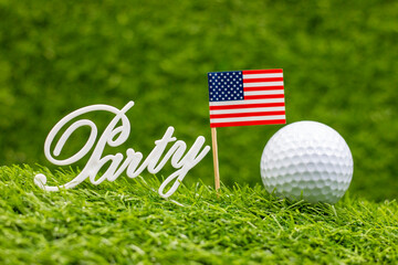 Golf ball with flag of America on green grass