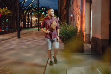 Man with waist bag walks in the night city