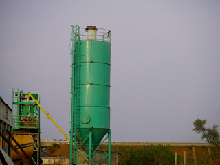 concrete mixer cylinder for construction work presenting around sky industrial backdrop.