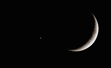 Fototapeta na wymiar the crescent moon and planet venus in close proximity to each other
