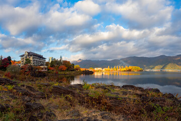 Hotel on shores of Lake Kawaguchiko. Japan in sunny weather. Sunrise over Lake Kawaguchiko. Autumnal nature Japan. Tourist hotel in Japanese city. Fujikawaguchiko travel guide. Japan rising sun