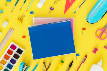 Back to school. Education concept. Everything for school and office. School supplies. Pens, pencils, notebook, glasses and everything for study on a yellow background. Flatly. From above.