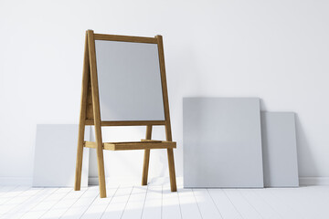 Wooden easel standing in an empty white room. 3d rendering
