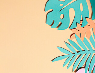 Fototapeta na wymiar Hand cut paper tropical plants leaves on the beige background. Summer concept Top view. Copy space 