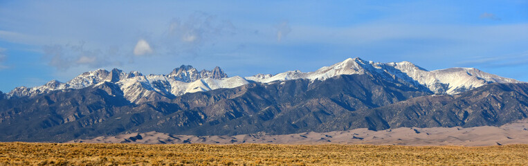 panoramic view of the crestone peaks and the sangre de cristo mountain range next to great sand dunes national park, near alamosa, colorado