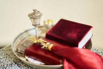 The Christian cross lies on top of the book of the Bible.