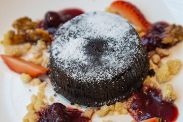 Chocolate fondant lava cake with strawberries serve on white plate