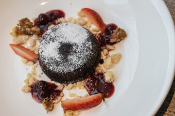 Chocolate fondant lava cake with strawberries serve on white plate