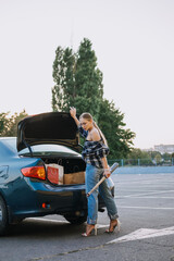 Girl power, feminism, women self-defense. Portrait of woman with baseball bat on parking outdoor. Young woman defend herself