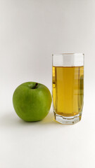 Green apple and clear glass of apple juice