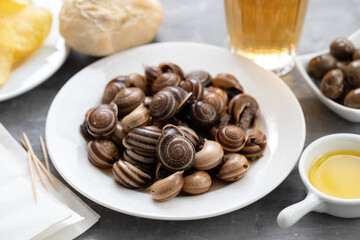 boiled snails with bear, bread, olives and potato chips
