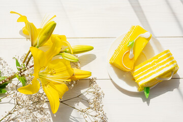 Yellow cake yellow lilies on a white wooden background in bright sunlight. Flowers cake for the...