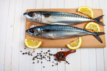 Raw mackerel on a cutting board with spices.