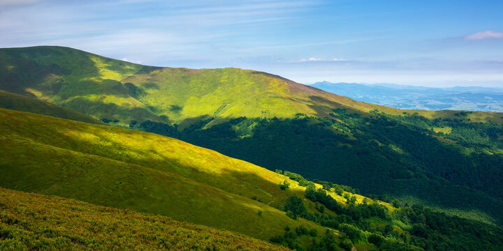 rolling hills an meadows of borzhava ridge. beautiful nature scenery with grassy slopes in dappled light. wonderful summer landscape of ukrainian carpathian mountains on a sunny day
