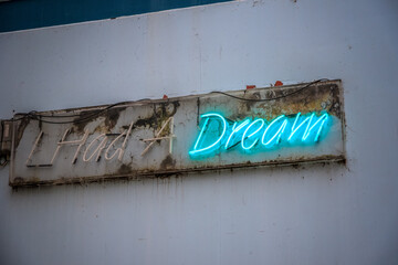 Blue neon sign I Had A Dream with only Dream being lit on London urban street - Powered by Adobe