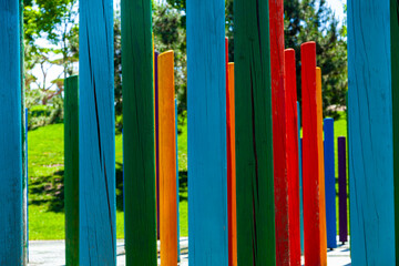 Multicolored wooden poles in a summer park