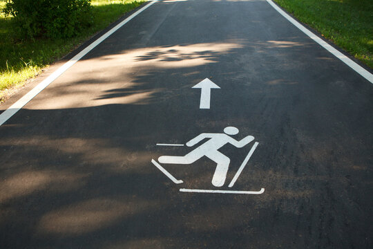 Roller skiing sign on the asphalt road in the park.