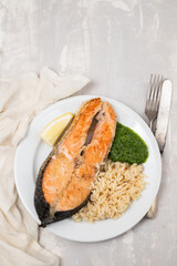 fried salmon with fresh lemon and spinach on white dish