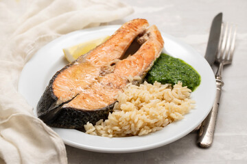 fried salmon with fresh lemon and spinach on white dish