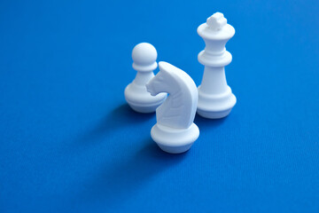 Chess pieces on a bright blue background. Abstract background. White chess figures for the game and strategy. Team building concept