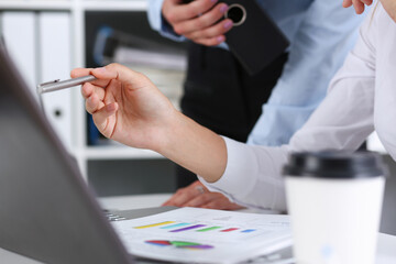 Group of people deliberate on problem with clipboard
