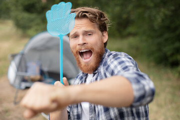 man trying to get rid of annoying insects