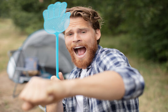 man trying to get rid of annoying insects