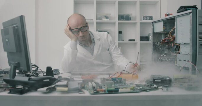 Stressed frustrated technician and broken computer