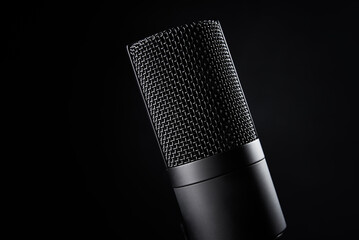 Studio microphone on dark background with copy space. Black professional condencer microphone....