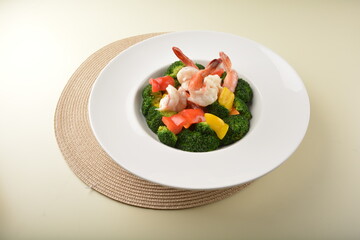 stir fried green broccoli with fresh big tiger prawn and bell pepper in oyster sauce in white plate asian halal menu